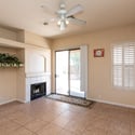 Relaxing family room featuring a fireplace, ceiling fan, and sliding glass door access to the backyard. A comfortable gathering space perfect for year-round enjoyment.