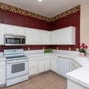 Well-appointed kitchen featuring plentiful cabinetry, tile countertops, and efficient workspace. The practical layout supports both everyday cooking and entertaining.