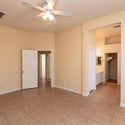 Spacious primary bedroom with high ceilings, tile flooring, and a ceiling fan for year-round comfort. A private retreat designed to accommodate a variety of furniture layouts.