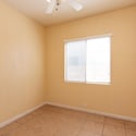 Secondary bedroom offering natural light, tile flooring, and versatile functionality. Perfect for guests, family members, a study, or a dedicated workspace.