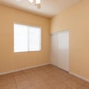 Bright guest bedroom featuring closet storage, tile flooring, and a large window. A flexible space that adapts easily to changing household needs.