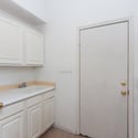 Dedicated laundry area with cabinetry, utility sink, and workspace for household tasks. Direct outdoor access adds practicality and convenience to this thoughtfully designed home.