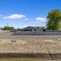 Wide-angle view emphasizes the property's generous acreage, fenced boundaries, and open surroundings, providing outstanding privacy and endless possibilities for outdoor living or future expansion.