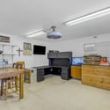Convenient office space within the detached workshop includes built-in workspace, storage cabinets, and room for managing projects or business operations without leaving the property.