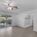 Spacious primary bedroom includes updated flooring, ceiling fan, large sliding glass door, and direct access to the covered patio, blending indoor comfort with outdoor living.