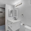 Elegant remodeled bathroom features an oversized tiled shower with built-in storage niche, updated vanity, modern fixtures, and stylish finishes designed for lasting appeal.