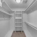 Large walk-in closet provides built-in shelving, multiple hanging sections, and generous storage space to help keep wardrobes neatly organized and easily accessible.