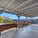 Relax beneath the covered patio while enjoying raised garden beds, attractive paver walkways, and low-maintenance landscaping that creates a welcoming outdoor living environment.