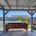 Covered patio overlooks raised planter boxes, paver pathways, and spacious backyard landscaping, offering an inviting outdoor area perfect for gardening, entertaining, and enjoying Arizona living in Goodyear.