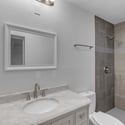 Updated bathroom features a marble-look vanity, contemporary fixtures, and a beautifully tiled walk-in shower, delivering a clean and timeless design with quality finishes.