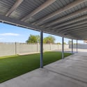 Oversized covered patio offers generous shaded seating with views of the landscaped backyard, making it ideal for outdoor dining, gatherings, and relaxing throughout the year.