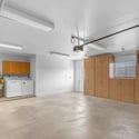 Functional oversized garage features built-in cabinets, laundry hookups, extra storage, and plenty of room for vehicles, tools, and workshop space.