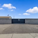 Secure metal gate and block wall fencing create a private entrance with convenient access for oversized vehicles, recreational equipment, and extra parking flexibility.