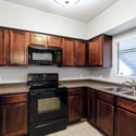 Rich wood cabinetry, generous countertops, updated appliances, and a convenient double-basin sink make this kitchen both practical and inviting. The efficient design supports everyday cooking with ease.