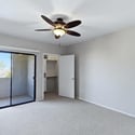 This spacious bedroom offers balcony access, a walk-in closet, ceiling fan, and neutral finishes that create a bright, comfortable, and move-in-ready retreat.