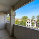 This spacious covered balcony offers relaxing outdoor living with beautiful mountain views, mature trees, and attractive community landscaping, making it the perfect extension of the home's living space.