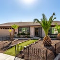 Beautiful desert landscaping, palm trees, decorative rock accents, and an inviting walkway create exceptional curb appeal. This Scottsdale home's attractive exterior offers low-maintenance beauty.