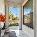 The covered entry welcomes guests with a bright foyer and an inviting transition into the home's spacious interior. Natural light enhances this warm and functional entryway.