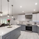 The updated kitchen features an impressive quartz island, contemporary cabinetry, stainless steel appliances, and elegant lighting. Designed for cooking, gathering, and entertaining with ease.
