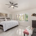 The spacious primary bedroom provides a relaxing escape with plantation shutters, elegant finishes, abundant natural light, and room for a sitting area. Comfort and functionality come together beautifully.