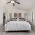 Designed for comfort, the primary bedroom features oversized windows, stylish finishes, tile flooring, and excellent natural light. A relaxing space that complements the home's updated interior.
