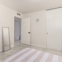 Additional bedroom view showcasing generous floor space, closet access, neutral finishes, and plantation shutters that enhance comfort and natural light throughout.