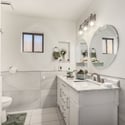 Stylish guest bathroom featuring a contemporary vanity, updated lighting, elegant mirrors, and a beautifully renovated walk-in shower with premium finishes.