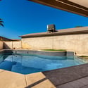 Private backyard retreat featuring a sparkling swimming pool, relaxing spa, covered patio, and easy-care outdoor living space perfect for enjoying Scottsdale's beautiful weather.