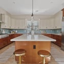 Featuring quartz countertops, premium stainless steel appliances, extensive cabinetry, double ovens, and a large center island, this gourmet kitchen is perfectly equipped for cooking and entertaining.