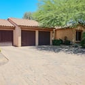 An oversized 3.5-car garage, generous paver driveway, gated access, and mature desert landscaping create a striking first impression while providing outstanding parking and storage.