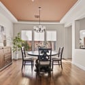 Designed for entertaining, this formal dining room features rich wood flooring, tray ceilings, abundant natural light, and seamless access to the gourmet kitchen and living areas.