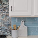 Decorative tile backsplash, quartz countertops, custom cabinetry, and quality finishes showcase the craftsmanship found throughout this beautifully updated Scottsdale kitchen.