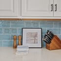 This kitchen workspace showcases expansive quartz countertops, decorative tile accents, custom cabinetry, and ample prep space designed for effortless cooking and entertaining.