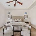 This luxurious owner's suite offers a spacious layout, tray ceiling, plush carpeting, and abundant room for a seating area, creating a relaxing private retreat.
