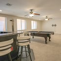 The spacious finished basement provides ample room for billiards, movie nights, gatherings, and flexible recreation while offering easy access to the adjacent custom wet bar.