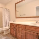 Conveniently located in the finished basement, this full bathroom offers custom wood cabinetry, expansive vanity space, tile flooring, and a tub/shower combination for added functionality.