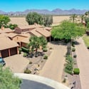 An impressive aerial view captures the home's generous lot, mature landscaping, neighboring properties, mountain backdrop, and desirable Scottsdale setting.