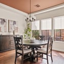This elegant dining room combines warm wood flooring, tray ceiling details, and abundant natural light to create the perfect space for entertaining and memorable family gatherings.