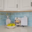 Beautiful quartz countertops, decorative blue tile backsplash, and custom cabinetry combine to create an elegant workspace in this thoughtfully designed Scottsdale kitchen.
