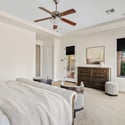 A second perspective highlights the spacious owner's suite with private patio access, tray ceiling, oversized proportions, and comfortable living space designed for relaxation.