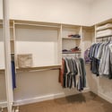 Custom closet organizers, built-in shelving, and extensive hanging space provide exceptional storage and organization within this oversized primary walk-in closet.