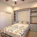 Featuring custom built-in cabinetry, integrated shelving, a desk workspace, plush carpeting, and generous closet space, this room easily adapts to your lifestyle needs.