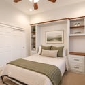 Professionally staged to showcase its flexibility, this bedroom features built-in cabinetry, a dedicated workspace, and comfortable accommodations for guests or everyday living.