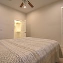 A comfortable secondary bedroom featuring plush carpeting, a ceiling fan, and convenient access to the adjacent bathroom. A flexible living space ideal for guests, family members, or a home office in Scottsdale.