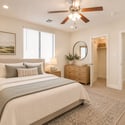 Virtually staged to inspire, this basement bedroom showcases generous proportions, soft carpeting, ceiling fan, walk-in closet, and comfortable guest accommodations within this Scottsdale home.