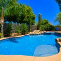 This inviting backyard combines a custom pool, spa, natural rock waterfall, mature landscaping, and expansive outdoor space to create a true Scottsdale retreat.