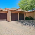 A spacious paver driveway leads to the three-car garage with carriage-style doors, complemented by mature landscaping and attractive architectural details for outstanding curb appeal.