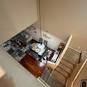 A bird's-eye perspective showcases the impressive vaulted ceilings, open dining area, wood flooring, and spacious living room designed for comfortable everyday living.