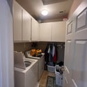 A dedicated interior laundry room offers built-in cabinetry, storage space, and convenient access to keep household chores organized and efficient in this Phoenix home.