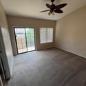 The spacious owner's suite offers vaulted ceilings, plush carpeting, abundant natural light, and direct access to the private balcony, creating a relaxing personal retreat.